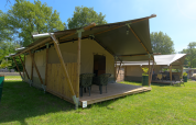 Safari-Zelt auf dem Campingplatz De Rammelbeek in den Niederlanden, mit Terrasse und Gartenmöbeln.