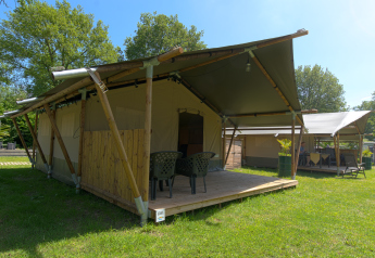 Safari-Zelt auf dem Campingplatz De Rammelbeek in den Niederlanden, mit Terrasse und Gartenmöbeln.