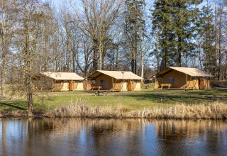 Tiendas safari junto al lago en Hunzepark, Países Bajos, perfectas para acampar en la naturaleza.