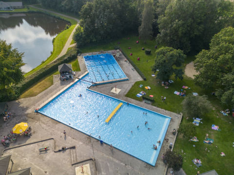 Vista aérea de piscinas, estanque y zonas verdes en el parque vacacional Hunzepark en Drenthe, Países Bajos.