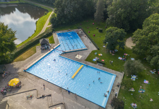 Vista aérea de piscinas, estanque y zonas verdes en el parque vacacional Hunzepark en Drenthe, Países Bajos.