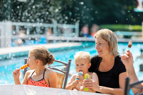Una familia disfruta de helados junto a la piscina en Hunzepark, un parque vacacional en Drenthe, Países Bajos.