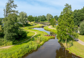 Vista aérea de senderos y un río pequeño en Hunzepark, un parque vacacional en Drenthe, Países Bajos.