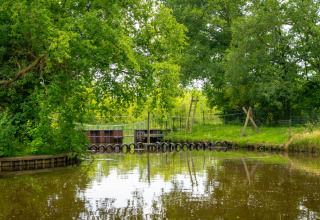 Lac entouré de verdure et parcours d'obstacles au Hunzepark, parc de vacances à Drenthe, Pays-Bas.