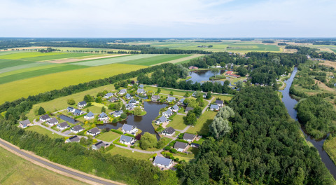 Vista aérea de Hunzepark, parque vacacional en Drenthe, Países Bajos, rodeado de naturaleza y agua.