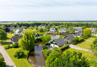 Aerial view of Hunzepark holiday park in Drenthe, Netherlands, with cabins, water features, and greenery.