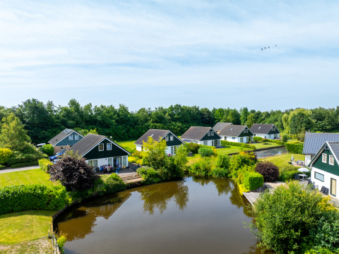 Casas de vacaciones junto a un estanque en Hunzepark, un parque vacacional en Drenthe, Países Bajos.