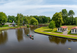 Vue aérienne du parc de vacances Hunzepark à Drenthe, Pays-Bas, avec canoës sur l’eau et verdure.