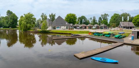 Colorati kayak vicino al lago e edifici moderni al parco vacanze Hunzepark, Drenthe, Paesi Bassi.