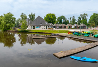 Kayaks coloridos junto al lago y edificios modernos en el parque vacacional Hunzepark en Drenthe, Países Bajos.