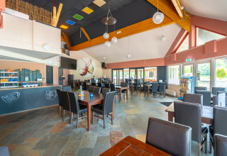 Moderno comedor con luz natural en Hunzepark, parque vacacional en Drenthe, Países Bajos, con muebles elegantes.