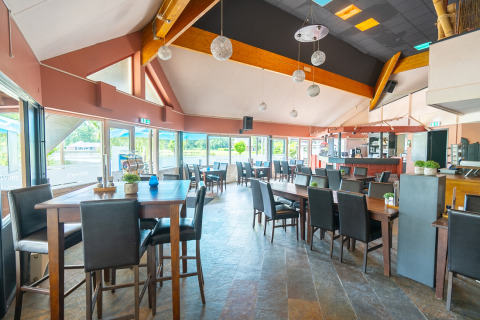 Sala da pranzo moderna con grandi finestre presso Hunzepark, parco vacanze a Drenthe, Paesi Bassi.
