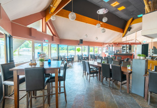 Sala da pranzo moderna con grandi finestre presso Hunzepark, parco vacanze a Drenthe, Paesi Bassi.