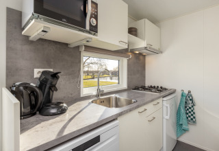 Kitchenette moderne avec évier, plaques de cuisson, micro-ondes et vue, Chalet Comfort 4, Hunzepark, Pays-Bas.