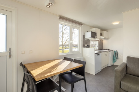 Bright, modern kitchen and dining area at Chalet Comfort 4 in Hunzepark, Netherlands, with outdoor view.