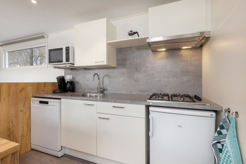 Cucina moderna dello Chalet Comfort 6 a Hunzepark, Paesi Bassi, con frigorifero, fornelli e lavastoviglie.