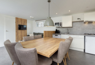 Moderne spise- og opholdsområde med køkken i Chalet Comfort 6 på Hunzepark, Nederlandene.
