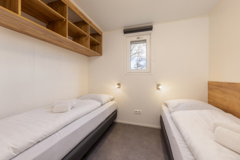 Habitación luminosa con dos camas individuales en el Chalet Comfort 6 de Hunzepark, Países Bajos.