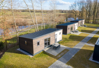 Vista aérea de los chalets Comfort 6 en Hunzepark, Países Bajos, rodeados de vegetación y árboles.
