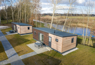 Dos cabañas Chalet Comfort 6 en Hunzepark, Países Bajos, junto a un lago y rodeadas de naturaleza.