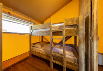 Indvendigt billede af Safari tent 6 på Hunzepark i Holland med køjeseng og lyse gule vægge.