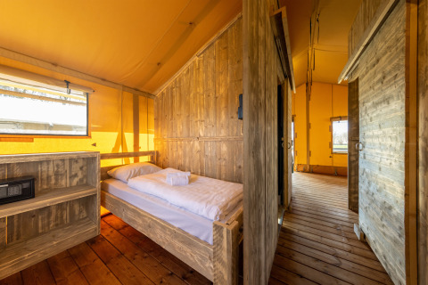 Vue intérieure de la tente Safari 6 à Hunzepark, Pays-Bas, avec mobilier en bois et ambiance chaleureuse.