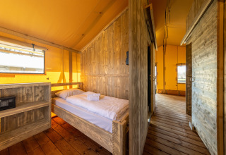 Vue intérieure de la tente Safari 6 à Hunzepark, Pays-Bas, avec mobilier en bois et ambiance chaleureuse.