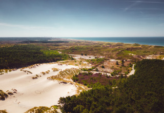 Luftfoto af sandklitter, skov og hav nær Callassande feriepark i Nordholland, Holland, på en klar dag.