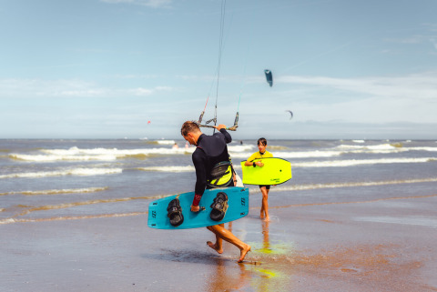 Dos personas con tablas se preparan para hacer kitesurf y bodyboard en la playa cerca de Callantsoog, Países Bajos.