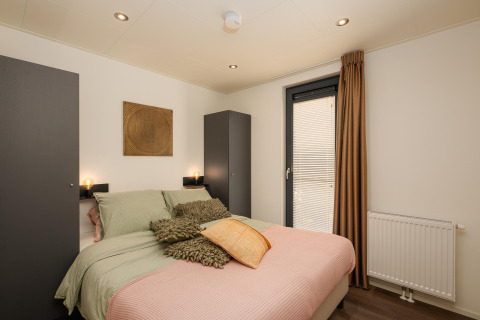 Modernes Schlafzimmer in der Cannenburch Deluxe Lodge bei de Bosgraaf, Niederlande, mit stilvoller Einrichtung.