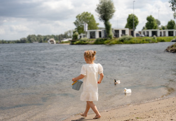 Meisje in witte jurk aan het water bij Villa Maritiem, MarinaPark Bad Nederrijn in Nederland.