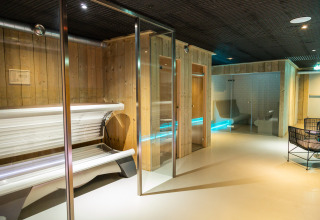 Foto di un'area benessere con lettini abbronzanti e saune in un alloggio glamping con pareti in legno.