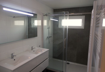 Moderne badkamer in Lodge 4 van Breeduyn Village, België, met dubbele lavabo en grote douche.