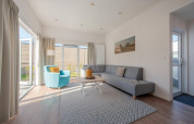 Helles, modernes Wohnzimmer in der Lodge 6 im Breeduyn Village, Belgien, mit großen Fenstern und stilvoller Einrichtung.