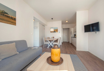 Sala luminosa y moderna de la Lodge 6 en Breeduyn Village, Bélgica, con comedor y zona de cocina abierta.