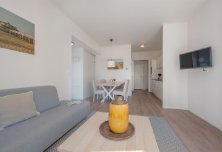 Sala luminosa y moderna de la Lodge 6 en Breeduyn Village, Bélgica, con comedor y zona de cocina abierta.