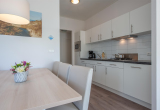 Helle, moderne Küche mit Essbereich in der Lodge 6 des Breeduyn Village in Belgien, schlicht und gemütlich.