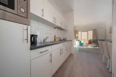 Cucina e soggiorno moderni nella Lodge 6 di Breeduyn Village, Belgio, con arredi luminosi e eleganti.