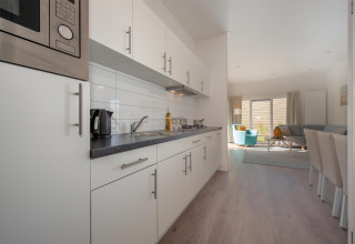 Modernes Küche und Wohnzimmer in Lodge 6, Breeduyn Village, Belgien, mit hellem Interieur.
