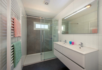 Modernes Badezimmer mit großer Dusche, Doppelwaschbecken und farbigen Handtüchern in Lodge 6, Breeduyn Village.