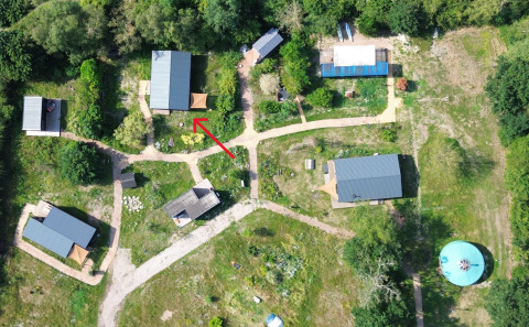 Luftaufnahme von Slowlodge Sage bei Zomerlicht in den Niederlanden mit rotem Pfeil auf eine Hütte.