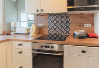 Cucina moderna presso Le Chalet sous les Hetres in Belgio, con fornelli, forno e elettrodomestici.