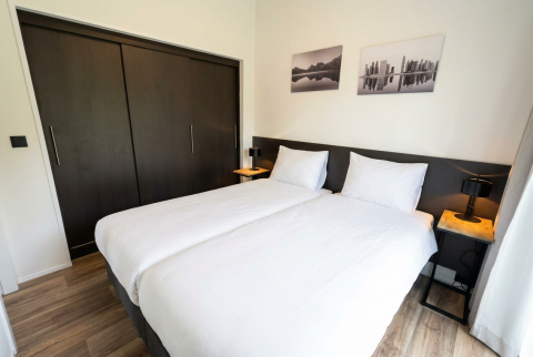 Slaapkamer in Hackfort 4 lodge op De Utrechtse Heuvelrug met twee aparte bedden en strakke inrichting.