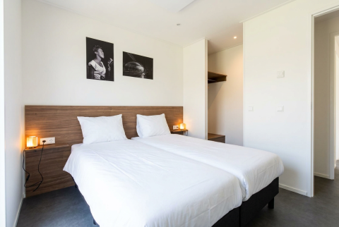 Stijlvolle lodgekamer bij L-Cube 4 met twee aparte bedden en wanddecoratie in De Utrechtse Heuvelrug, Nederland.