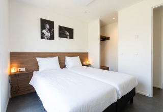 Stijlvolle lodgekamer bij L-Cube 4 met twee aparte bedden en wanddecoratie in De Utrechtse Heuvelrug, Nederland.