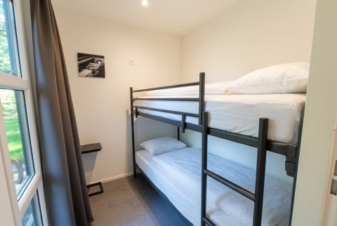 Moderne lodgekamer in L-Cube 4, De Utrechtse Heuvelrug, met stapelbed en kunstwerk aan de muur.