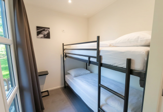 Moderne lodgekamer in L-Cube 4, De Utrechtse Heuvelrug, met stapelbed en kunstwerk aan de muur.
