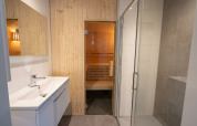 Modernes Badezimmer mit Waschbecken, Dusche und Zugang zu einer Sauna in einer Lodge auf De Utrechtse Heuvelrug.