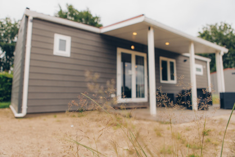 Photo of Dune Lodge at Duinhoeve in the Netherlands, showing its modern exterior and covered patio.