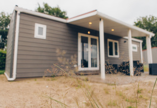 Photo of Dune Lodge at Duinhoeve in the Netherlands, showing its modern exterior and covered patio.
